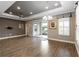 Elegant living space featuring a tray ceiling, chandelier, and sliding glass doors at 911 Tidal Pond Dr, Groveland, FL 34736