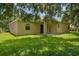 Rear view of home shows back porch, and lush green yard at 9650 Bay Pine Ln, Orlando, FL 32832