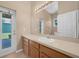Bright bathroom with a large mirror, wood cabinets, and a white sink at 9650 Bay Pine Ln, Orlando, FL 32832