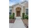Elegant front entryway with a arched doorway and well-maintained landscaping at 9650 Bay Pine Ln, Orlando, FL 32832