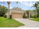 Charming single-story home with a well-manicured lawn, mature palm trees and two-car garage at 9650 Bay Pine Ln, Orlando, FL 32832