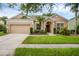 Inviting home featuring a manicured lawn, two car garage, and lush landscaping at 9650 Bay Pine Ln, Orlando, FL 32832
