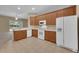 Open kitchen with tile floors, wood cabinets, and white appliances with open view to backyard at 9650 Bay Pine Ln, Orlando, FL 32832