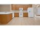 Clean kitchen featuring tiled flooring, wooden cabinets, and modern white appliances at 9650 Bay Pine Ln, Orlando, FL 32832
