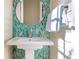 Powder room featuring a white pedestal sink and unique teal decorative tile backsplash at 10143 Mattraw Pl, Golden Oak, FL 32836