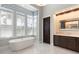 Bright bathroom with marble floors, soaking tub, and a large window offering an abundance of natural light at 10143 Mattraw Pl, Golden Oak, FL 32836