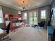 Spacious bedroom with coral bunk beds, an attached desk, and a door to a balcony at 10143 Mattraw Pl, Golden Oak, FL 32836