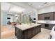 Kitchen with central island, open to the living spaces, features a wine fridge, and modern appliances at 10143 Mattraw Pl, Golden Oak, FL 32836