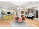 Open-concept living space featuring hardwood floors, a dining area, living room, and kitchen with island seating at 10143 Mattraw Pl, Golden Oak, FL 32836