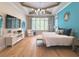 This main bedroom features recessed ceilings, light wood flooring, and windows with decorative curtains at 10143 Mattraw Pl, Golden Oak, FL 32836