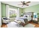 Bright bedroom with a ceiling fan, king bed, lots of light, and hardwood floors at 1073 Sadie Ln, Winter Garden, FL 34787