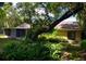 Backyard with lush greenery and a view of the home with a screened patio at 1102 Winter Springs Blvd, Winter Springs, FL 32708