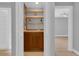 Cozy bar area featuring wooden cabinets, shelving, and a sink, perfect for entertaining guests at 1102 Winter Springs Blvd, Winter Springs, FL 32708