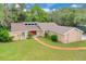 Stunning home featuring a well-manicured lawn, mature trees and an inviting red door at 1102 Winter Springs Blvd, Winter Springs, FL 32708