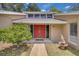 Eye-catching red double doors with transom windows, complemented by lush landscaping and a fountain at 1102 Winter Springs Blvd, Winter Springs, FL 32708