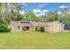 Beautiful single-story home with well-manicured lawn and a red front door under a blue sky at 1102 Winter Springs Blvd, Winter Springs, FL 32708