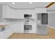 Renovated kitchen featuring white cabinets, stainless steel appliances, and wood floor at 1102 Winter Springs Blvd, Winter Springs, FL 32708