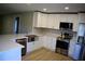 Bright kitchen with stainless steel appliances, white cabinets, and a large basin sink at 1102 Winter Springs Blvd, Winter Springs, FL 32708