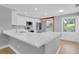 Bright kitchen with stainless appliances, white cabinets, a long breakfast bar, and wood floors at 1102 Winter Springs Blvd, Winter Springs, FL 32708