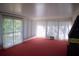 Spacious living room with red carpet, large window with vertical blinds and an AC unit at 1102 Winter Springs Blvd, Winter Springs, FL 32708