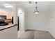 Open dining area with elegant wainscoting and modern light fixture adjacent to a kitchen with black appliances at 12843 Madison Pointe # 208, Orlando, FL 32821