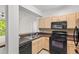 Modern kitchen equipped with black appliances and a practical layout, ideal for cooking and serving at 12843 Madison Pointe # 208, Orlando, FL 32821