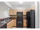 Efficient kitchen features black appliances and ample cabinetry, perfect for preparing meals and entertaining guests at 12843 Madison Pointe # 208, Orlando, FL 32821