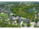 Aerial view showcases the neighborhood's beautiful homes, tranquil pond, and lush greenery creating a serene environment at 14252 Anastasia Ln, Orlando, FL 32828