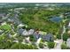 Aerial view showcases the neighborhood's beautiful homes, tranquil pond, and lush greenery creating a serene environment at 14252 Anastasia Ln, Orlando, FL 32828