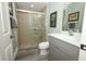 Well-lit bathroom features a glass enclosed shower, grey vanity, and light wood look flooring at 14252 Anastasia Ln, Orlando, FL 32828