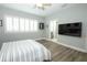 A light filled bedroom features wood look flooring, a ceiling fan, and an adjacent bathroom at 14252 Anastasia Ln, Orlando, FL 32828