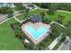 Aerial view of the community pool featuring lounge seating, lush hedges, and a unique shape for leisure and recreation at 14252 Anastasia Ln, Orlando, FL 32828
