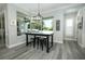 Casual dining area with gray hardwood floors, decorative lighting, large window, and neutral paint at 14252 Anastasia Ln, Orlando, FL 32828