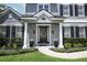 Inviting front entrance with decorative wreath, potted plants, and lush landscaping at 14252 Anastasia Ln, Orlando, FL 32828
