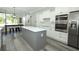 Bright kitchen with stainless appliances, subway tile backsplash, white cabinets, and large gray island at 14252 Anastasia Ln, Orlando, FL 32828