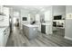 Open kitchen with white cabinets, subway tile backsplash, and large gray island with durable gray hardwood floors at 14252 Anastasia Ln, Orlando, FL 32828
