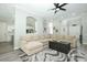 Comfortable living room with neutral paint, gray hardwood floors, and open floor plan to kitchen at 14252 Anastasia Ln, Orlando, FL 32828