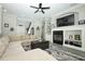 Cozy living room with a ceiling fan, neutral paint, gray hardwood floors, and fireplace at 14252 Anastasia Ln, Orlando, FL 32828