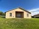 Rear exterior view of the home featuring a covered patio area and well-maintained lawn at 1433 Bluff Loop, Dundee, FL 33838