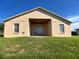 Back exterior view of home featuring a covered patio area and well-maintained lawn at 1433 Bluff Loop, Dundee, FL 33838
