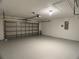 Spacious garage with epoxy flooring, bright lighting, and an automatic door opener at 1433 Bluff Loop, Dundee, FL 33838