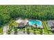 Aerial view of the community pool, pool house, splash pad, and playground with a forest in the background at 15343 Lebeau Loop, Winter Garden, FL 34787