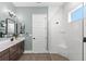 Bathroom featuring double sinks, a modern shower with glass partition and a white door at 15343 Lebeau Loop, Winter Garden, FL 34787