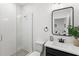 Modern bathroom with glass shower, white subway tile, dark vanity, and rectangular framed mirror at 15343 Lebeau Loop, Winter Garden, FL 34787