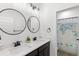 Modern bathroom features double sinks, black fixtures, round mirrors, and a unique map shower curtain at 15343 Lebeau Loop, Winter Garden, FL 34787