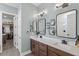 Modern bathroom with double sinks, sleek mirrors, and a door to the walk-in closet at 15343 Lebeau Loop, Winter Garden, FL 34787