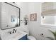 Stylish half-bath features a modern sink, decorative mirror and neutral wall decor at 15343 Lebeau Loop, Winter Garden, FL 34787