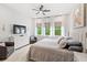 Bright bedroom with a ceiling fan, three large windows, and stylish furnishings at 15343 Lebeau Loop, Winter Garden, FL 34787
