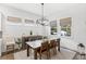 Bright dining room features a wooden table, modern light fixture, and large windows at 15343 Lebeau Loop, Winter Garden, FL 34787