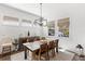 Bright dining room with modern light fixture, large table and chairs, and views of the outdoor landscape at 15343 Lebeau Loop, Winter Garden, FL 34787